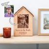A photo of an old man in a wooden house on a shelf.