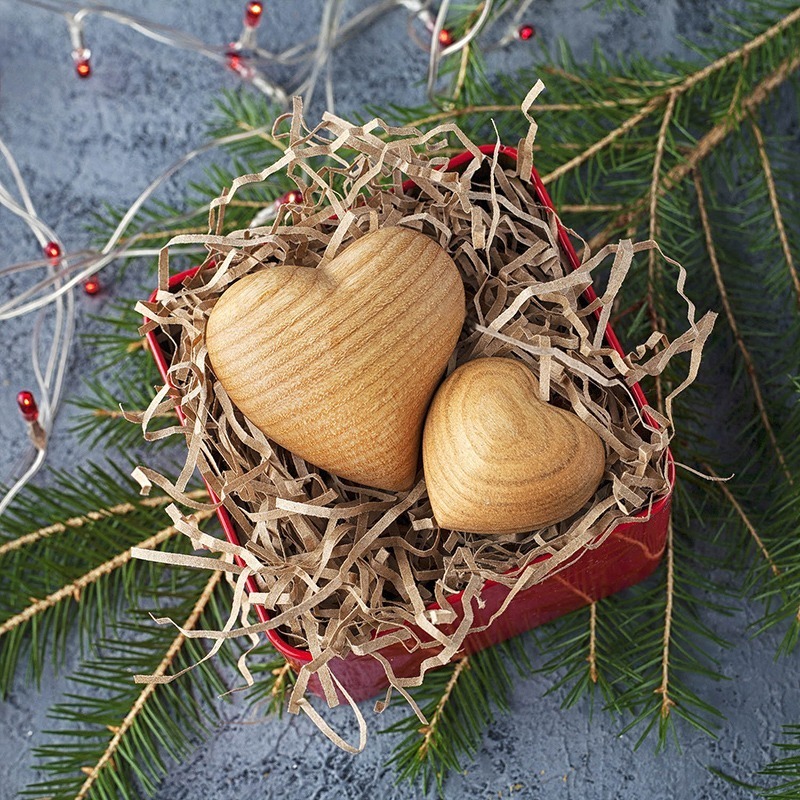 Two wooden hearts in a red box.