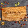 Personalized live edge charcuterie board with engraving and laying on top of a kitchen counter.