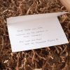 A note is sitting on top of a box of twigs.